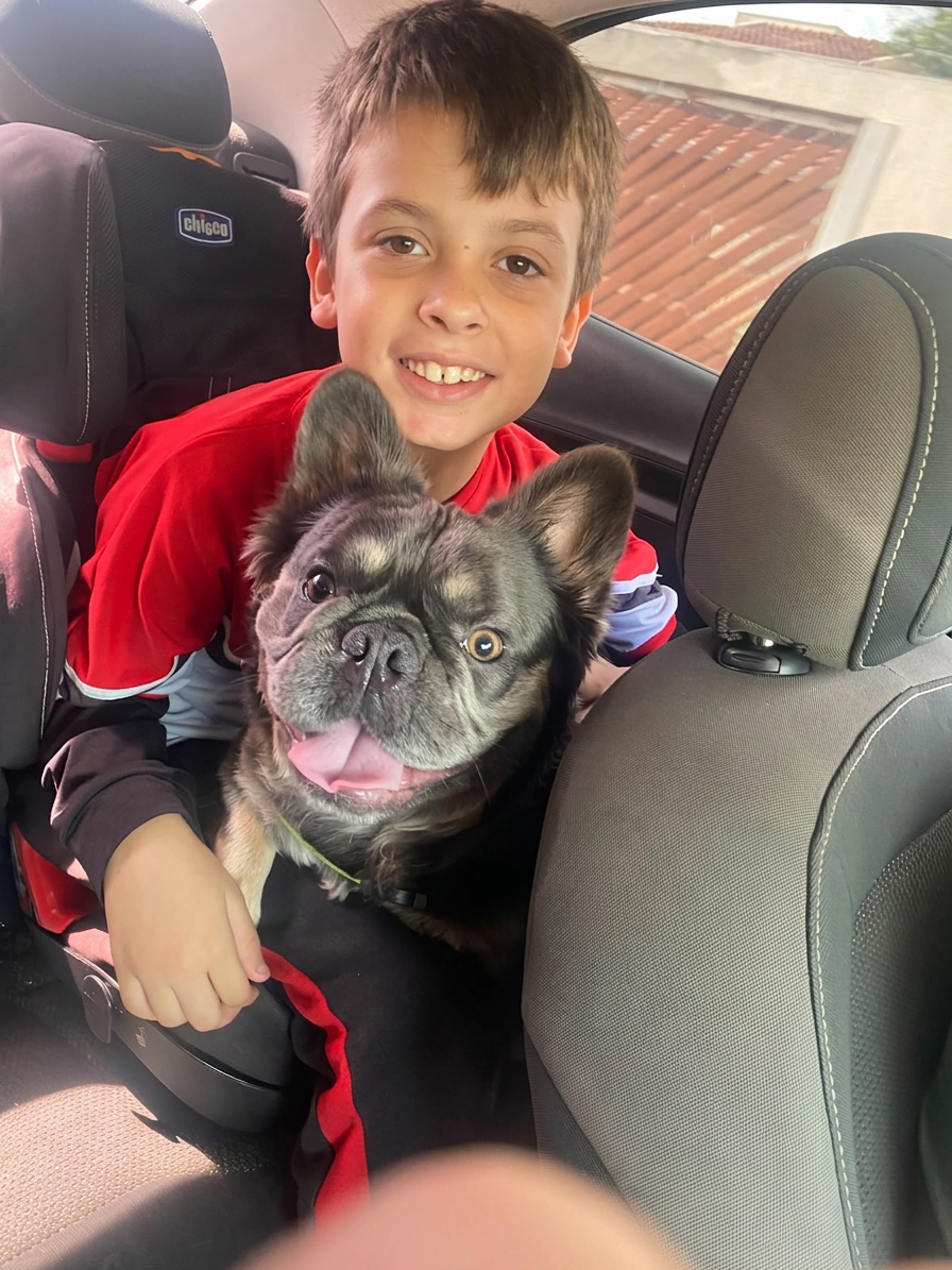 Criança abraçando bulldog francês
